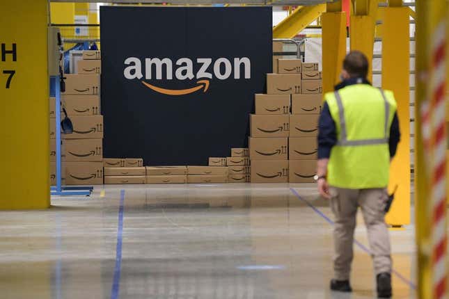 A US giant Amazon employee passes by its logo on the opening day of the new distribution center in Augny, eastern France, on September 23, 2021. 