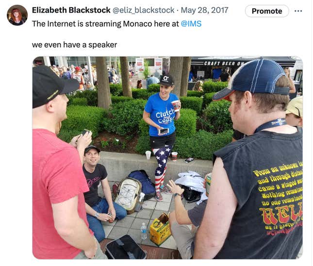 Un grupo de personas reunidas en las 500 Millas de Indy viendo el Gran Premio de Mónaco por teléfono móvil