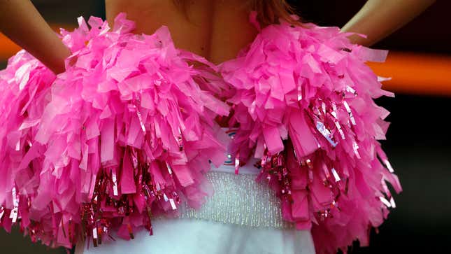 Cheerleader holds pink pom poms