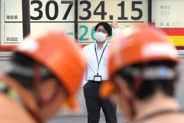 A person stands in front of an electronic stock board showing Japan&#39;s Nikkei 225 index at a securities firm Tuesday, Oct. 24, 2023, in Tokyo. Shares were mixed Tuesday in Asia after Wall Street wobbled to a mixed close as yields on U.S. Treasury bonds fell back after creeping above 5%. (AP Photo/Eugene Hoshiko)