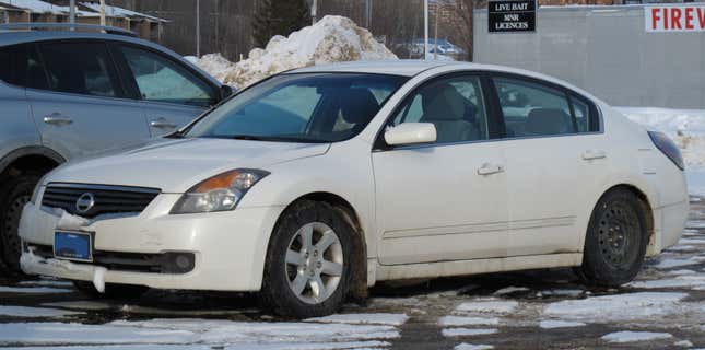 A wbite Nissan altima garée sur un terrain enneigé