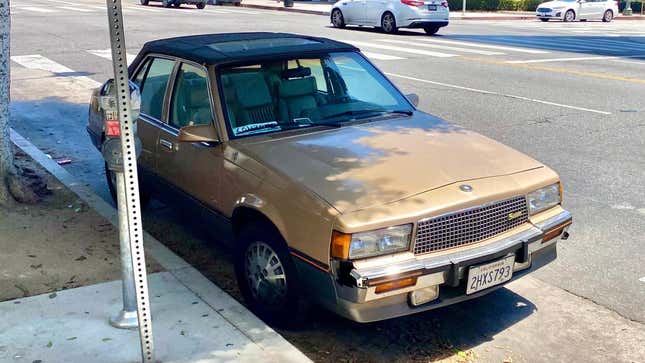 A front 3/4 shot of the gold Cimarron parked next to a parking meter