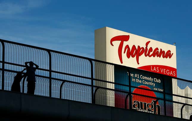 FILE - People stand on a pedestrian bridge by the Tropicana hotel and casino, Aug. 4, 2015, in Las Vegas. The Tropicana Las Vegas, a Sin City namesake for more than six decades, is slated to shut its doors in April 2024 to make room for a $1.5 billion Major League Baseball stadium, Bally&#39;s Corp. announced Monday, Jan. 29, 2024. (AP Photo/John Locher, File)