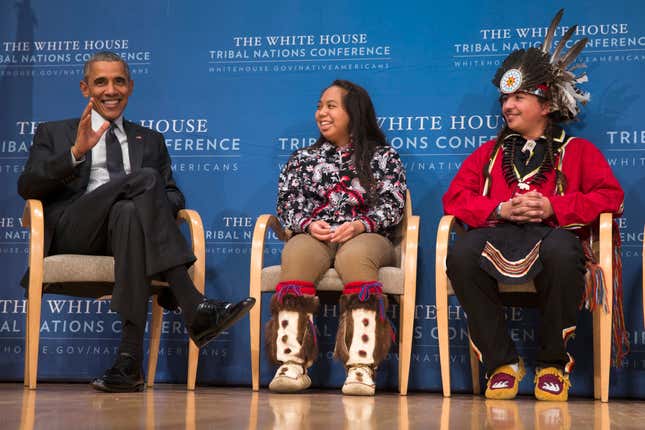 Brayden White of the St. Regis Mohawk Tribe, right, and Tatiana Ticknor of the Yup'ik/Tlingit/Dena'ina, listen as President Barack Obama speaks during the 2015 White House Tribal Nations Conference, Thursday, Nov. 5, 2015, in Washington. In conjunction with the conference, shoe company and apparel maker Adidas announced it will provide free design resources to schools looking to shelve Native American mascots, nicknames, imagery or symbolism.