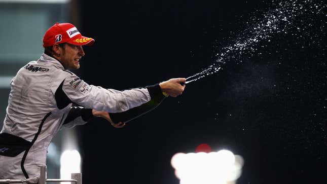 A photo of Jenson Button spraying Champagne on the podium. 