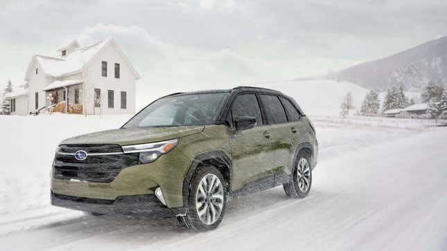 A green Forester Hybrid driving in a snow storm in front of a house and mountaint