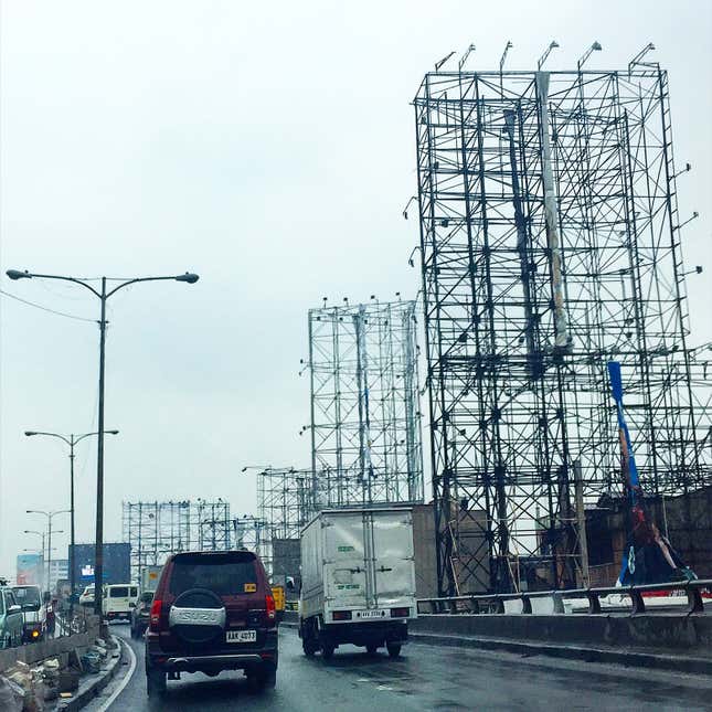 Image for article titled Photos: Dismantled billboards, ghostly scaffolds as a city braces for a typhoon