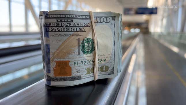 A roll of cash sitting on an airport's rolling sidewalk