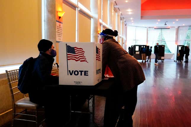 A poll worker talks to a voter before they vote on a paper ballot on Election Day in Atlanta on Tuesday, Nov. 3, 2020. A federal judge, on Thursday, Dec. 9 2021, has rejected motions to dismiss eight lawsuits that challenge Georgia’s sweeping new election law.