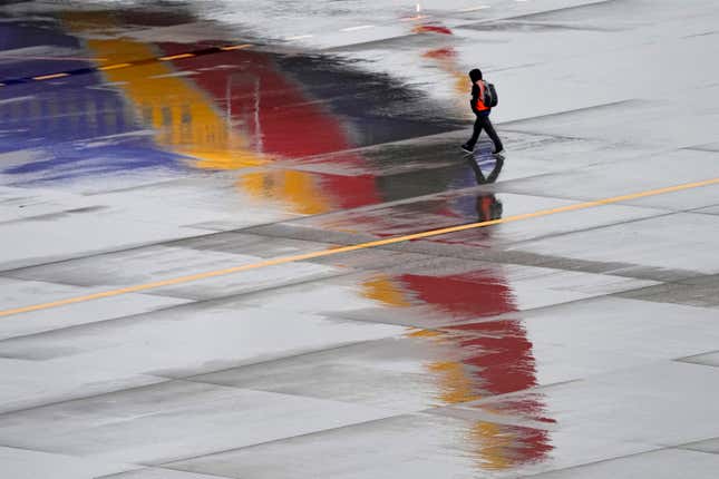 FILE - A ground operations crew member walks past a Southwest Airlines jet sitting at a gate, Dec. 28, 2022, at Sky Harbor International Airport in Phoenix. The federal government may be preparing to penalize Southwest Airlines for thousands of flight cancellations that affected more than 2 million travelers last December. Southwest disclosed the potential fine on Monday, Oct. 30, 2023 and said it couldn&#39;t estimate how large it might be. (AP Photo/Matt York, File)