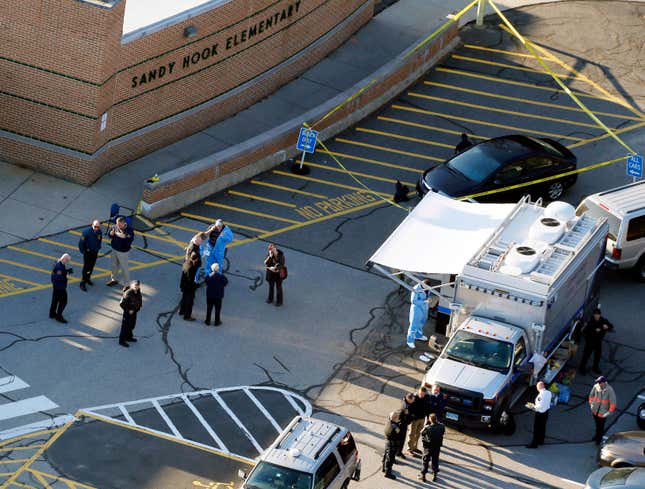 In this Dec. 14, 2012, photo, officials stand outside of Sandy Hook Elementary School after a shooting in Newtown, Conn. 