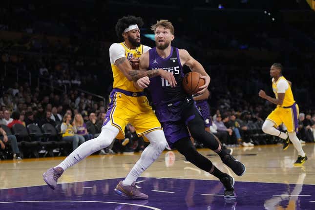 Nov 15, 2023; Los Angeles, California, USA; Sacramento Kings forward Domantas Sabonis (10) is defended by Los Angeles Lakers forward Anthony Davis (3) in the first half at Crypto.com Arena.