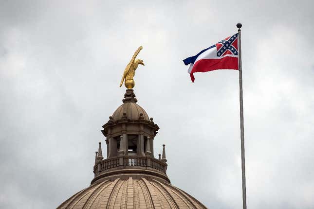 The old state flag flies over the Mississippi State Capitol building in Jackson, Mississippi on June 29, 2020.  Lawmakers in Mississippi voted to remove the Confederate battle standard from the state flag after nationwide protests drew renewed attention to symbols of the United States’ racist past.  