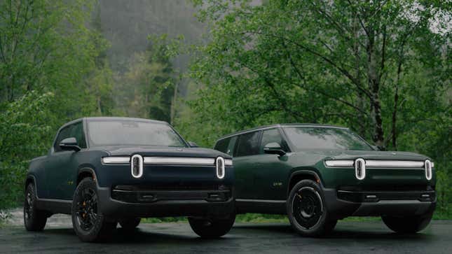 Una foto de un Rivian R1S y un R1T verdes estacionados uno al lado del otro en un bosque lluvioso 