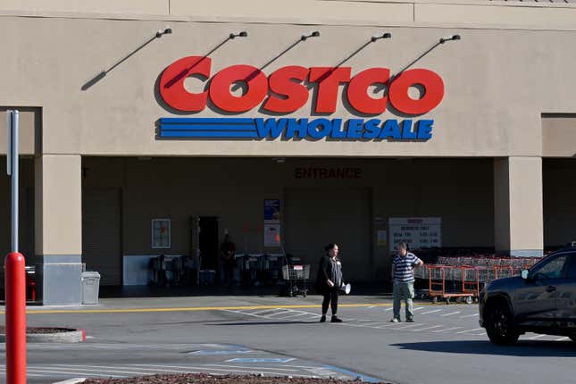 Workers inform customers about a power outage outside of a Costco in Foster City, California. 