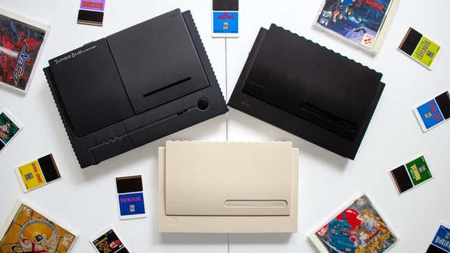 A 1992 NEC TurboDuo sits next to light- and a dark-colored Analogue Duo consoles, with HuCard and CD games scattered about.