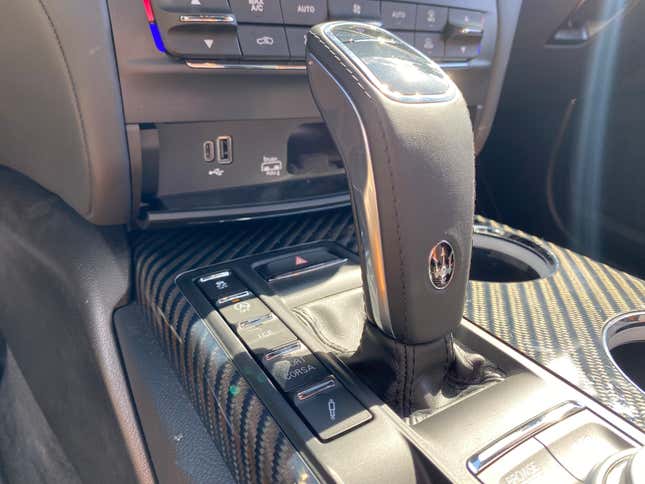 A photo of the center console near the shifter with the sport button and suspension button