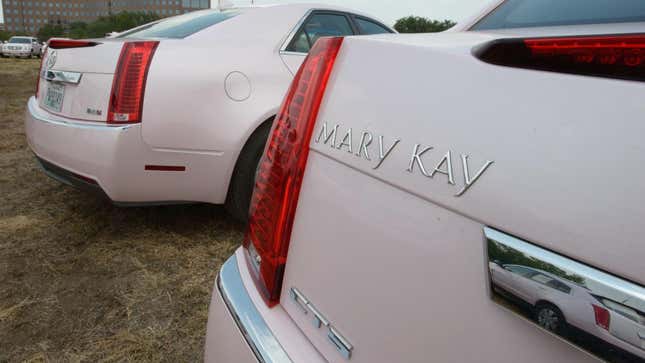 Eine Nahaufnahme des Mary-Kay-Abzeichens auf der Rückseite eines rosa Cadillac CTS