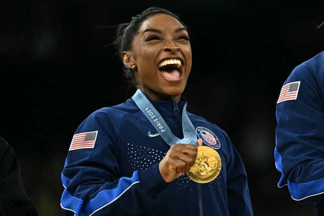 L’Américaine Simone Biles pose avec la médaille d’or lors de la cérémonie de podium pour la finale par équipes féminines de gymnastique artistique lors des Jeux Olympiques de Paris 2024 à la Bercy Arena de Paris, le 30 juillet 2024. 