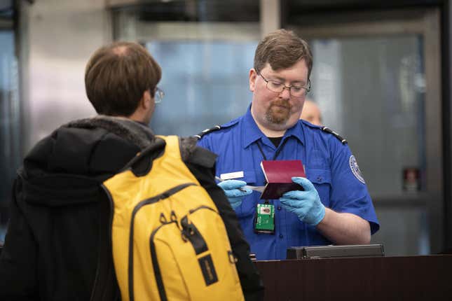 A Transportation Security Administration agent checks a flyer through security at O&amp;apos;Hare International Airport in 2019.