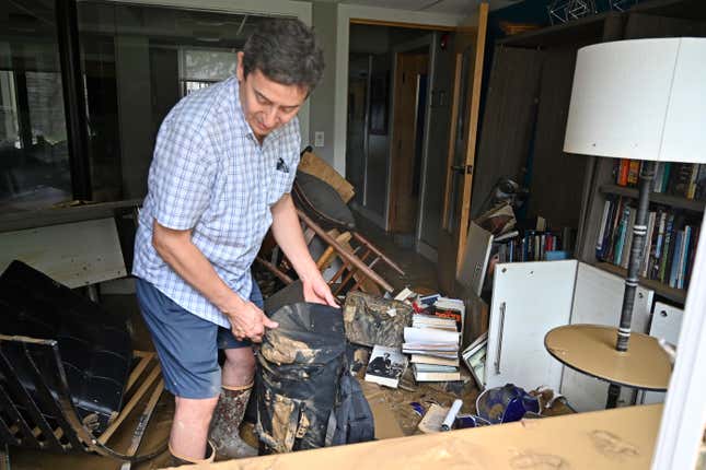 Will Anderson, Director of the Hindman Settlement School sorts through  the mud covered objects in his office in Hindman, Ky., Friday, July 29,  2022.