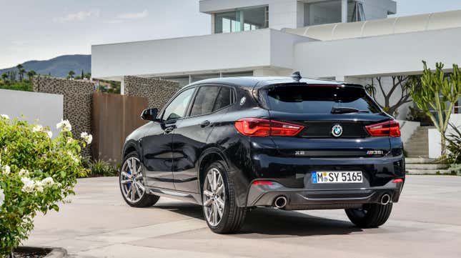 das Heck eines schwarzen BMW X2 , der vor einem Haus geparkt ist