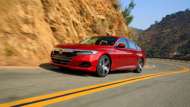 A red Honda Accord sedan driving on a highway. 