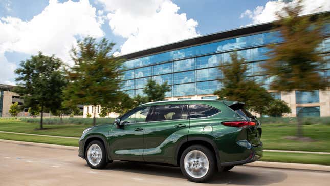 Toyota highlander driving in front of a glass building