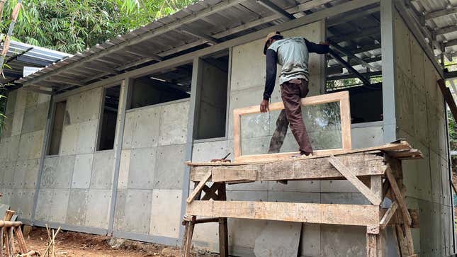 Photo of person performing construction work on a concrete building
