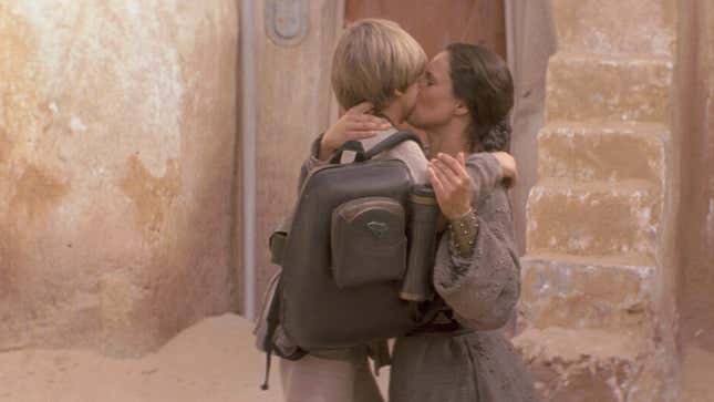 Anakin kisses Shmi goodbye.