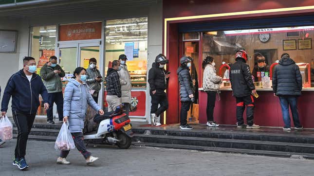 People line up to buy food at a booth in Xian, capital of northwest China’s Shaanxi Province, on Jan. 17, 2022 during the city’s strict lockdown.