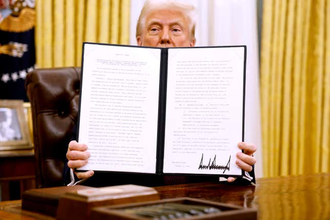 President Donald Trump holds up a signed executive order in the Oval Office of the White House on January 23, 2025, in Washington, DC. Trump signed a range of executive orders pertaining to issues including cryptocurrency.