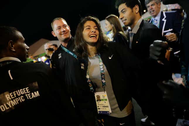 Refugee Olympic Team's Yusra Mardini, center, smiles during a welcome ceremony held at the Olympic village ahead of the 2016 Summer Olympics in Rio de Janeiro, Brazil, Wednesday, Aug. 3, 2016.
