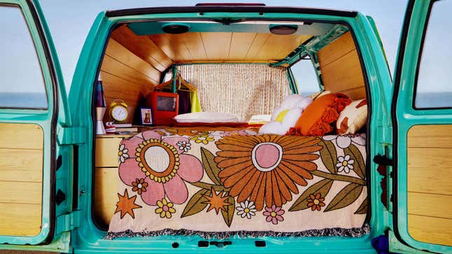 A close-up of the inside of the Mystery Machine is shown. A bed, old-fashioned TV, and lava lamp are visible.