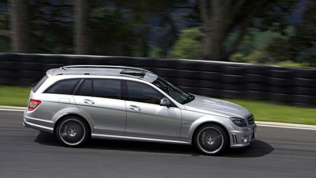 A silver S204 C63 AMG driving on a track form the side view