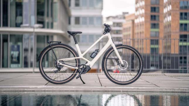 A photo of an Orbea electric bike next to some water. 