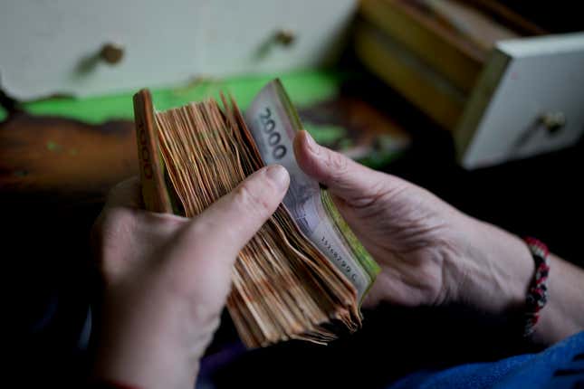 File - A worker counts money at a grocery store in Buenos Aires, Argentina, Nov. 21, 2023. In the past five years, Argentina&#39;s currency has lost about 90% of its value against the U.S. dollar. (AP Photo/Natacha Pisarenko, File)