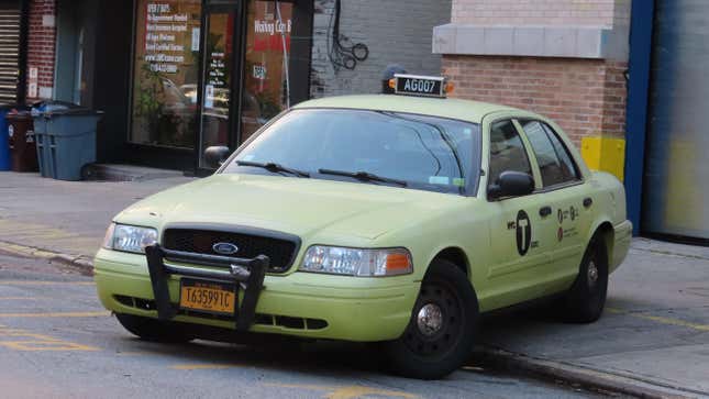 A light yellow police crown victoria with in new york taxi drag