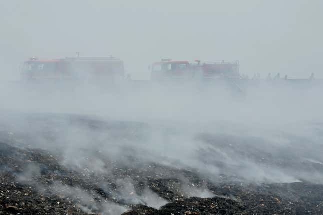 Firefighters are seen through smoke from a fire that razes through a landfill in Bekasi, on the outskirt of Jakarta, Indonesia, on Sept. 25, 2023. Pollution is causing respiratory illnesses and deaths to rise in Indonesia&#39;s island of Java, including the capital, Jakarta. Data gathered by IQAir, a Swiss air technology company, regularly ranks Jakarta as one of the most polluted cities in the world. Blue skies are a rare sight and the air often smells like fuel or heavy smoke. (AP Photo/Achmad Ibrahim)