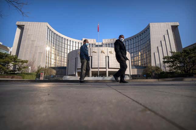 FILE - Pedestrians wearing face masks walk past the People&#39;s Bank of China in Beijing on March 3, 2023. China’s central bank said Wednesday, Jan. 24, 2024, it will cut the ratio of reserves banks must hold to help boost the slowing economy. (AP Photo/Mark Schiefelbein, File)