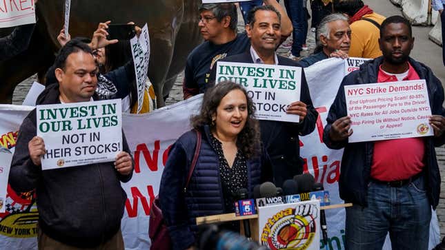 Bhairavi Desai of the New York Taxi Workers Alliance protests Uber and its investors by the Wall Street charging bull
