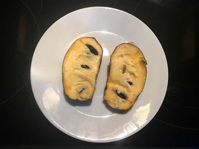 Pawpaw fruit split open on plate to show interior