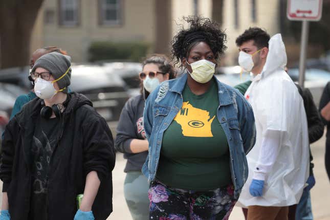 Voters wait in line at a polling place at Riverside University High School on April 07, 2020, in Milwaukee, Wisconsin. The voters waited sometimes more than two hours at the school, one of the few polling places open in the city after most were consolidated due to a shortage of poll workers fearful of contracting COVID-19.