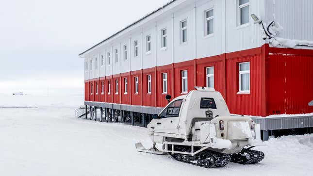 A snowmobile is parked next to a building at the Russian northern military base on Kotelny island.