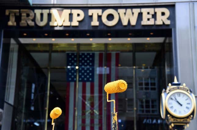 Activists raise their paint rollers as they paint a new Black Lives Matter mural outside of Trump Tower on Fifth Avenue on July 9, 2020 in New York City.