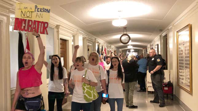 Protesters march through the halls of the Missouri Capitol outside the House chamber, May 17, 2019, in Jefferson City, Mo., in opposition to legislation prohibiting abortions at eight weeks of pregnancy. 
