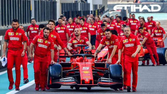 Members of the Ferrari team push the two cars out for a team photo before the final race of the 2019 season.