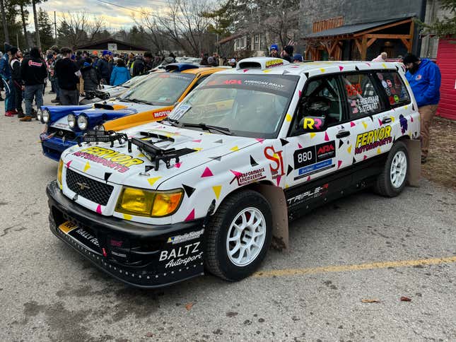 Vista frontal 3/4 de un auto de rally Subaru Forester blanco