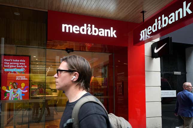 FILE - A man walks past a Medibank branch in Sydney on Oct. 26, 2022. A Russian national has been sanctioned on Tuesday, Jan. 23, 2024, by the Australian government for his role in a cyber attack which compromised the personal details of more than 10 million Australians. (AP Photo/Rick Rycroft, File)