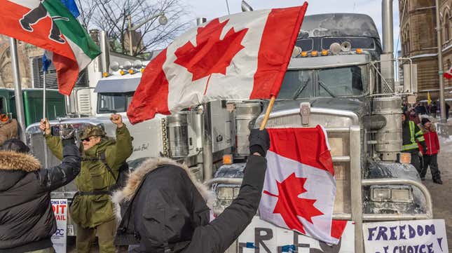  A woman waves a flag and cheers on truckers in protest of COVID-19 vaccine mandates on January 30, 2022 in Ottawa, Canada. Thousands turned up over the weekend to rally in support of truckers using their vehicles to block access to Parliament Hill, most of the downtown area Ottawa, and the Alberta border in hopes of pressuring the government to roll back COVID-19 public health regulations.